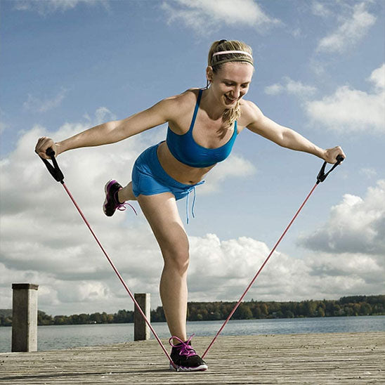 femme qui s'entraine à l'exterieur avec elastique musculation