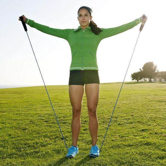 femme qui s'entraine en plein air avec elastique musculation